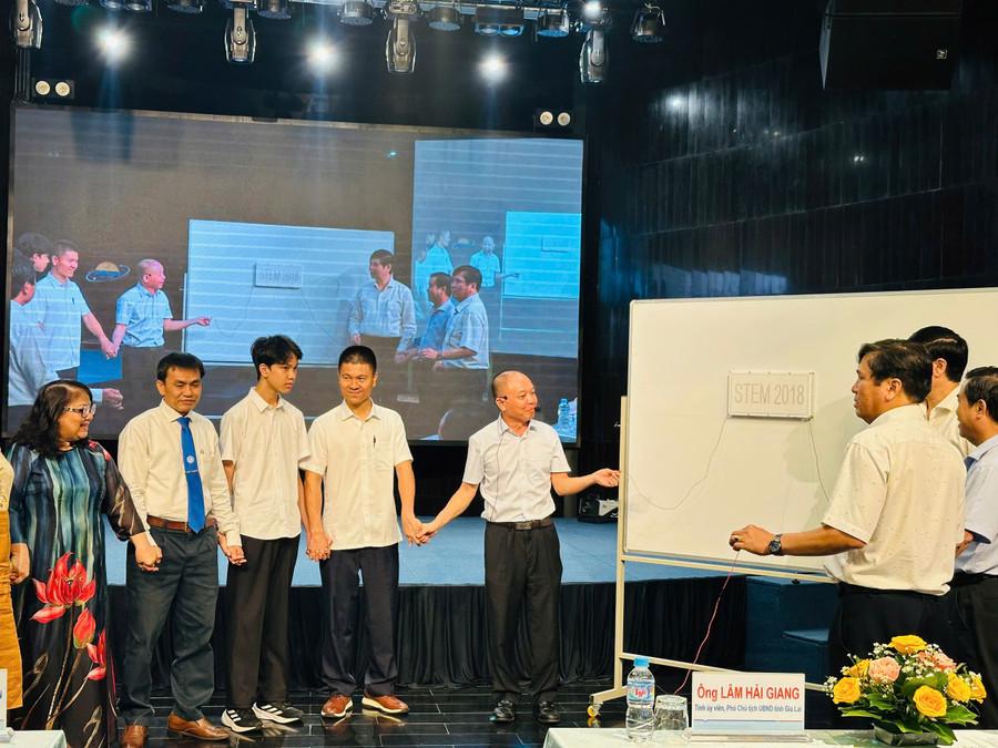Các đại biểu cùng giáo viên, học sinh thử nghiệm một thí dụ khoa học về dòng điện. Ảnh: Trương Trang gen-h-z6899273408325-98ebd9ed5f66d89eb9850aa81119d3b3.jpg