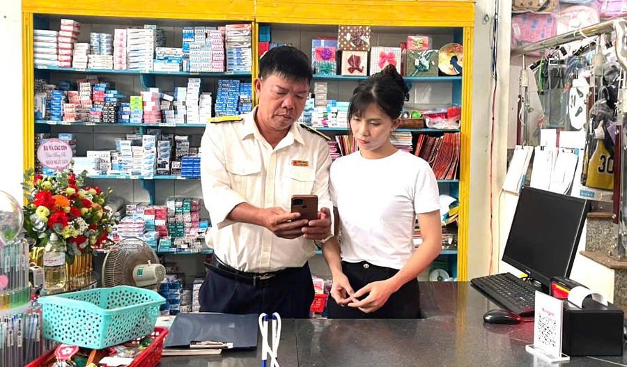 Cán bộ Thuế cơ sở 9 đồng hành, hỗ trợ hộ kinh doanh trong quá trình sử dụng eTax Mobile. Ảnh: Sơn Ca nop-thue-dien-tu.jpg