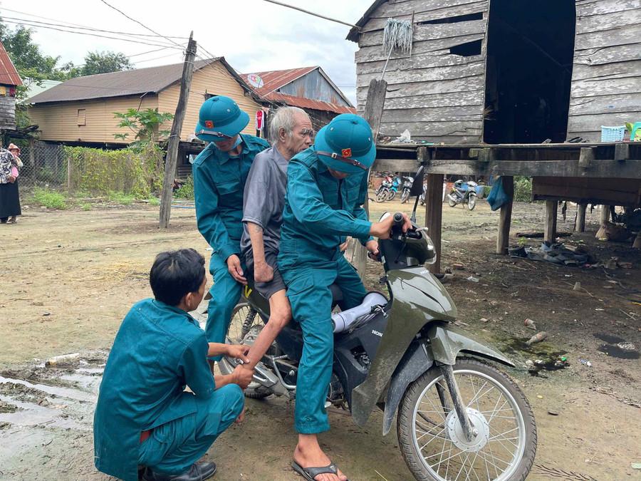 Lực lượng dân quân xã Ia Tul hỗ trợ đưa người già yếu đến nơi sơ tán an toàn. Ảnh: Vũ Chi ia-tul.jpg