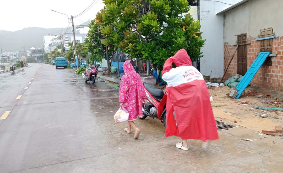 Người dân sống dọc bờ kè Nhơn Hải trong sáng nay khẩn trương di chuyển đến nơi trú tránh an toàn. Ảnh: Ngọc Nhuận nguoi-dan-song-doc-bo-ke-nhon-hai-tiep-tuc-so-tan-den-noi-an-toan-tranh-bao-1.jpg