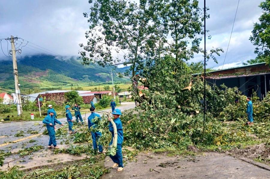 Lực lượng dân quân tự vệ xã Tơ Tung hỗ trợ người dân dọn dẹp cây gãy đổ sau bão. Ảnh: M.P ttung.jpg