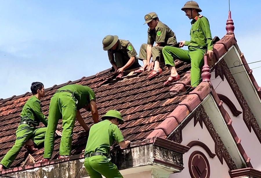 Công an xã Kbang hỗ trợ người dân sửa chữa nhà cửa hư hỏng do bão số 13 gây ra. Ảnh: M.C kbang.jpg
