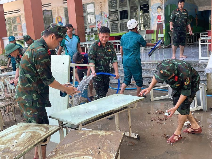 Lực lượng chức năng hỗ trợ dọn dẹp vệ sinh tại điểm Trường Tiểu học và THCS Quang Trung. Ảnh: Vũ Chi gen-h-z7204980097550-841eea54df075aa8c936e8860f4468da.jpg