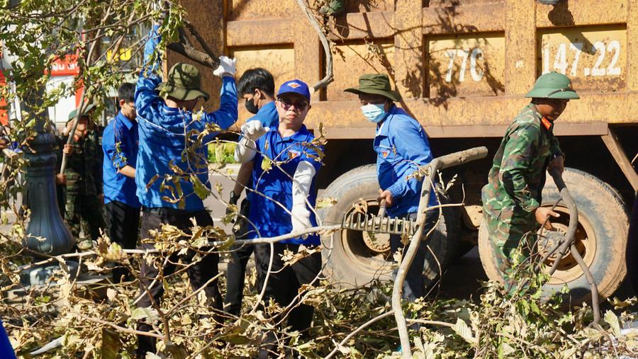 Đoàn viên thanh niên thu dọn cành cây gãy đổ do bão trên đường Nguyễn Tất Thành. Ảnh: D.L tinh-doan-ra-quan-don-ve-sinh-sau-bao-3.jpg