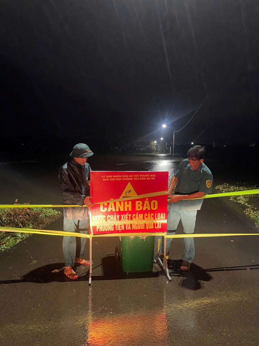 Ban Chỉ huy Phòng thủ dân sự xã Tuy Phước Bắc cắm biển cảnh báo tại tràn Nho Lâm khi phát hiện tràn bị ngập sâu vào đêm 18.11. Ảnh: ĐVCC tpb.jpg