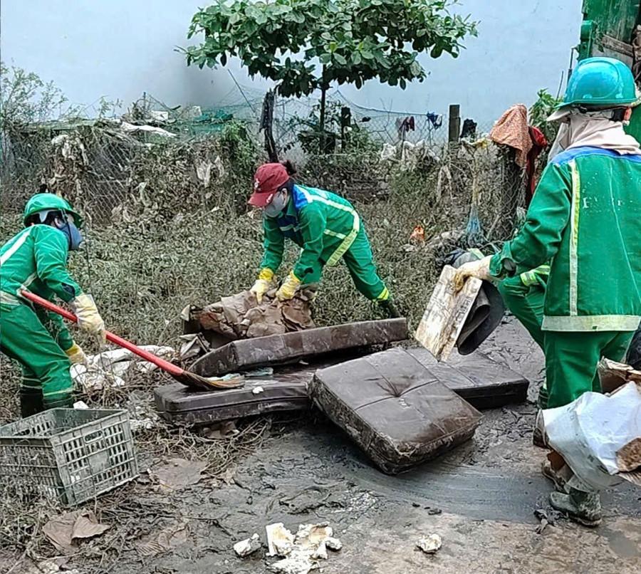 Công nhân Công ty cổ phần Môi trường Bình Định thu gom rác sau lũ ở đường Lạc Long Quân, phường Quy Nhơn Bắc trong sáng 22-11. Ảnh: Nguyễn Xuân anh-thu-gom.jpg