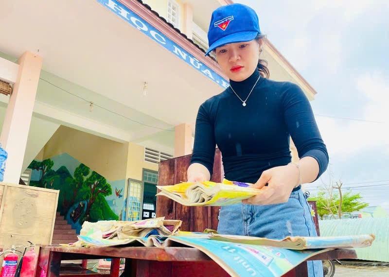 Giáo viên Trường Tiểu học số 2 Diêu Trì (xã Tuy Phước) phơi lại những quyển sách bị ướt do nước lũ. Ảnh: T.D gen-n-z7251114343666-676b9384d0d6cc899b475bd4a1aa5c18.jpg